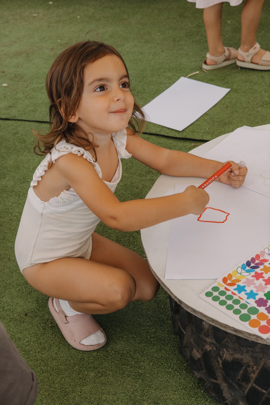 ילדה מציירת בשולחן יצירה על הדשא